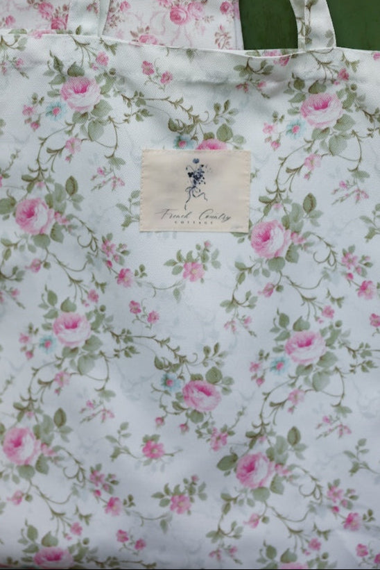 Floral patterned tote bag with a visible brand label against a green background